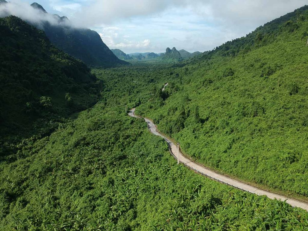 Phong Nha, Vietnam A road going through green mountains seen from above.