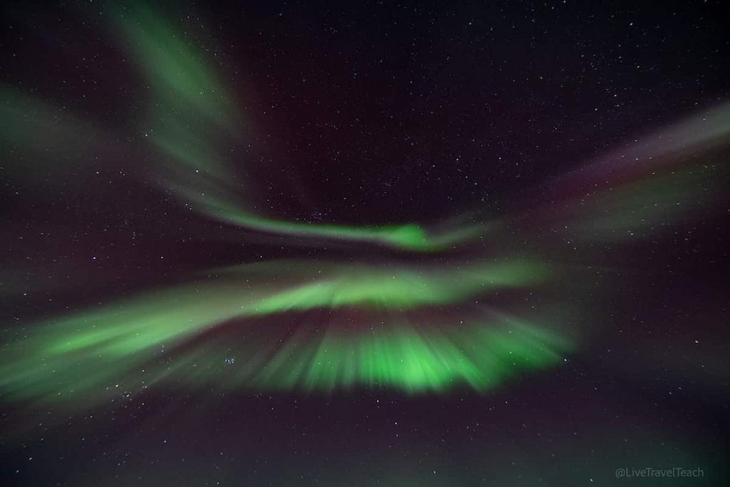 Chasing The Northern Lights Bright green Northern Lights dancing across the night sky in Alaska