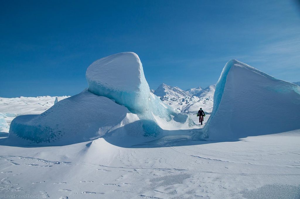 person fat biking across the frozen landscape of the Knik Glacier in Alaska