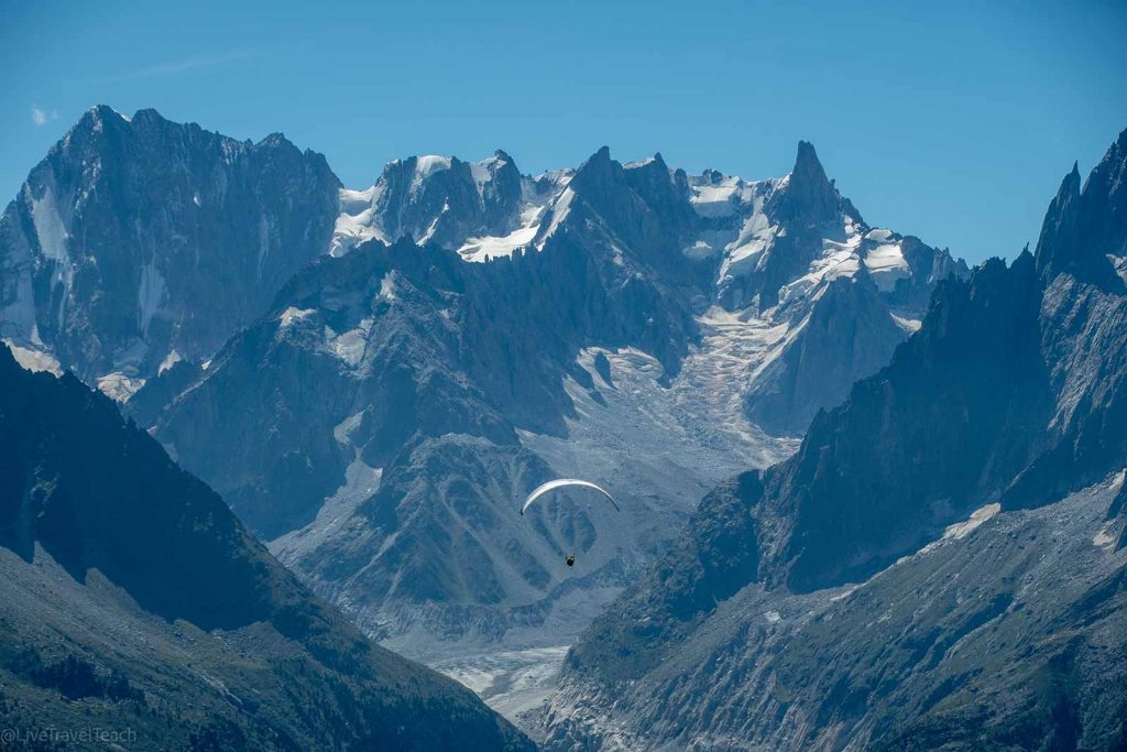 Tour du Mont Blanc a paraglider soaring in front of the Mont Blanc massif in the Chamonix Valley