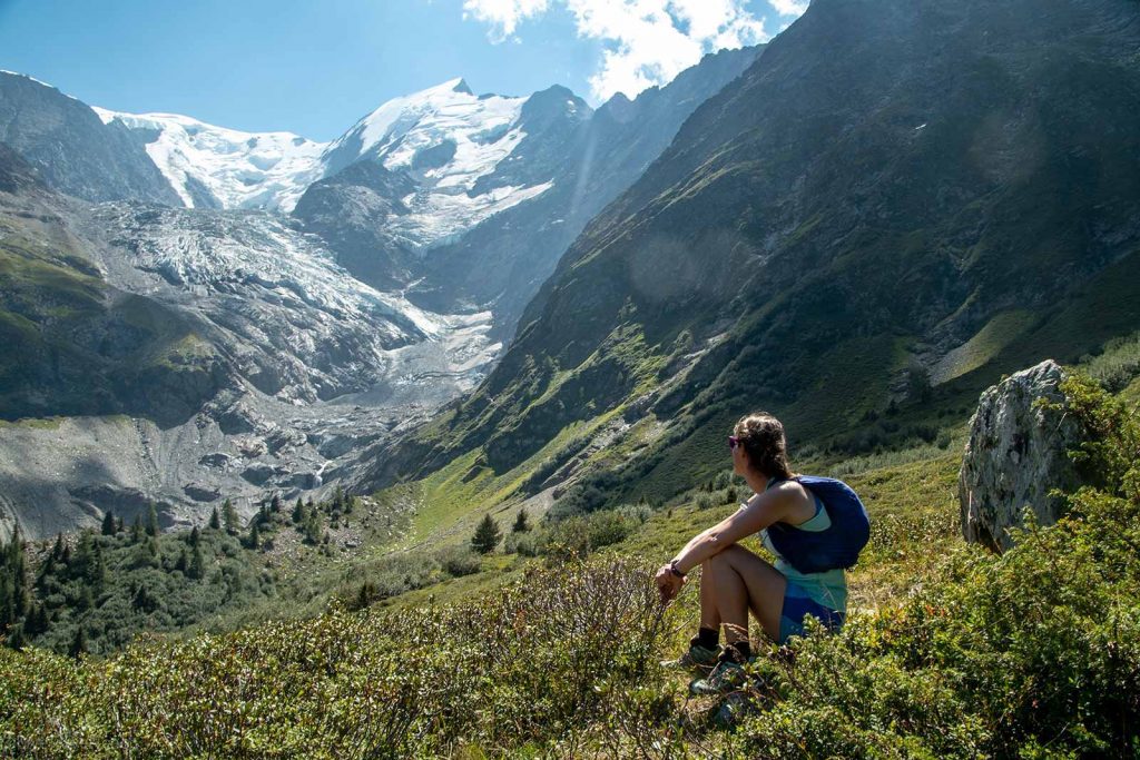 Tour du Mont Blanc hiker relaxing in an Alpine meadow while trekking the Tour du Mont Blanc