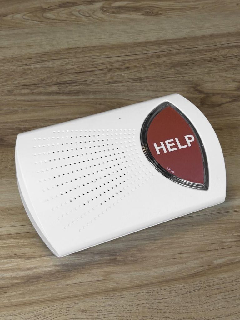 A Life Assure home medical alert kit with base unit and wearable help button